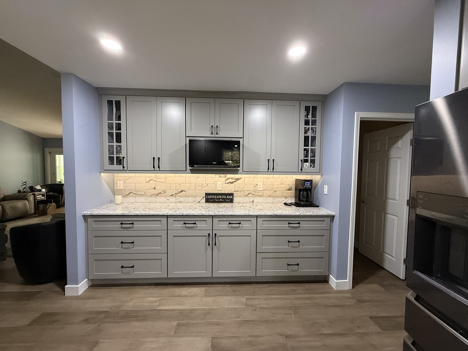 Coffee and wine bar with glass-front uppers, granite counter and marble tile backsplash