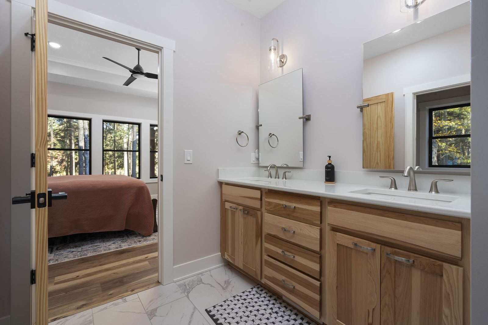 Hickory double vanity with quartz counters, open to the primary bedroom