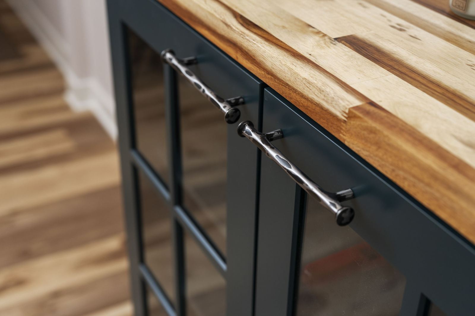 Navy island with a butcher block top and hammered nickel pulls