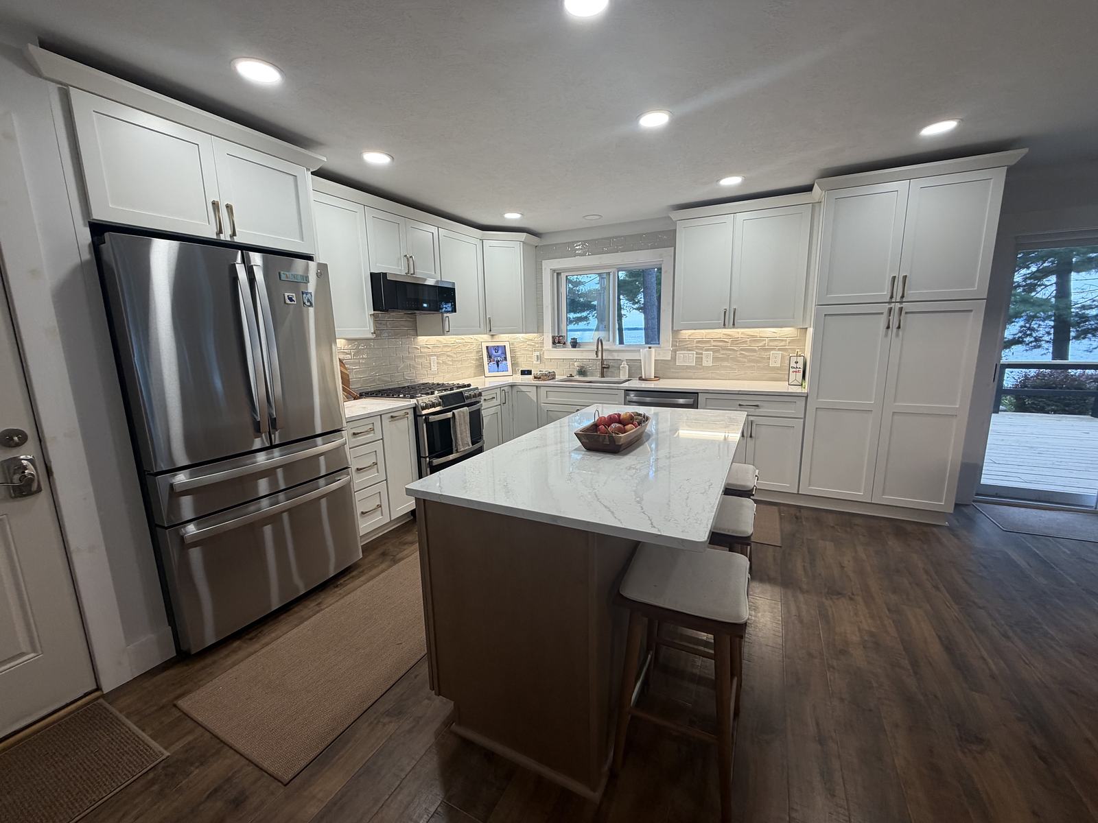 Open lakeview kitchen with full-height pantry cabinets and a quartz island