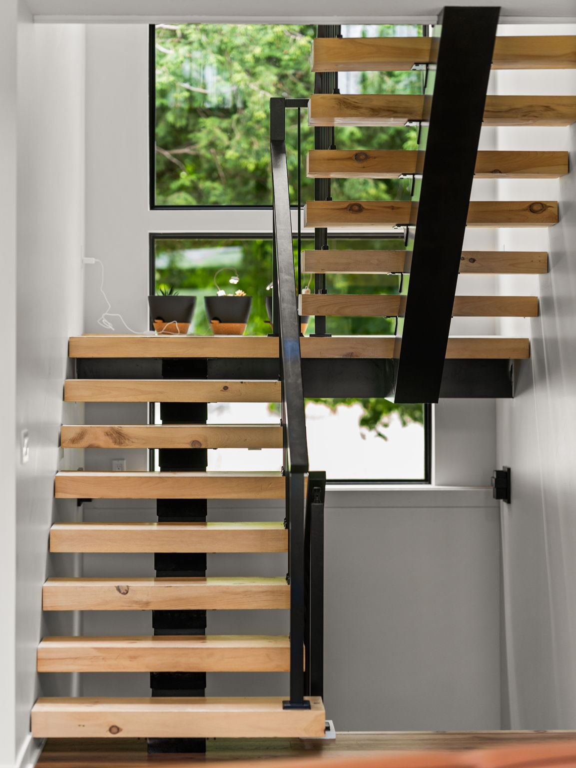 Open-tread staircase with wood treads, a steel stringer and glass rail